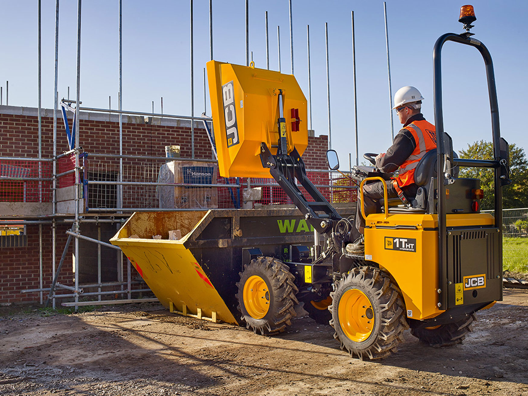 tradesman and construction with professional services insurance, building construction scene with labourer sitting in bright yellow j c b digger